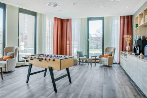 a living room with a foosball table and chairs at IntercityHotel Hamburg-Barmbek in Hamburg