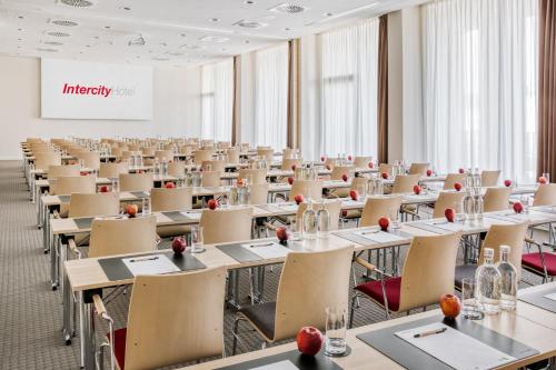 an empty room with tables and chairs and a whiteboard at IntercityHotel Hamburg-Barmbek in Hamburg