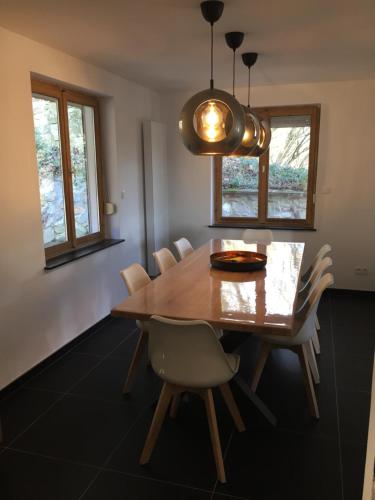 uma sala de jantar com uma mesa de madeira e cadeiras em Villa Odile em Malmedy