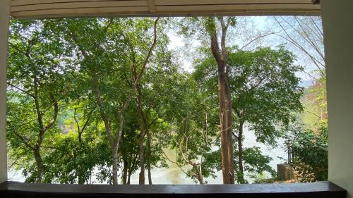 a window in a room with a view of trees at Saiyok River House in Sai Yok