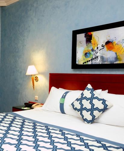 a bedroom with a bed with a blue and white comforter at Holiday Inn Al Khobar by IHG in Al Khobar