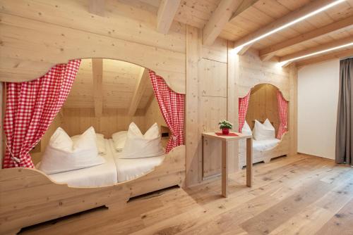 a room in a log cabin with a bed and mirrors at Naturhotel Runa in Rodengo