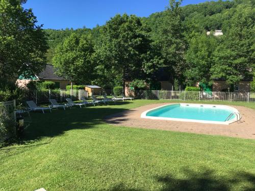 a swimming pool in the middle of a yard at Village 17 gites, Piscine, Restaurant , 2 gites avec SPA, 3km de Conques in Conques