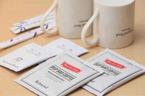 a table with two coffee mugs and a pair of glasses at Richmond Hotel Premier Kyoto Ekimae in Kyoto