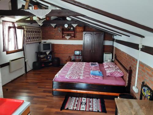 Un dormitorio con una cama grande en una pared de ladrillo. en Julijana, en Belgrado
