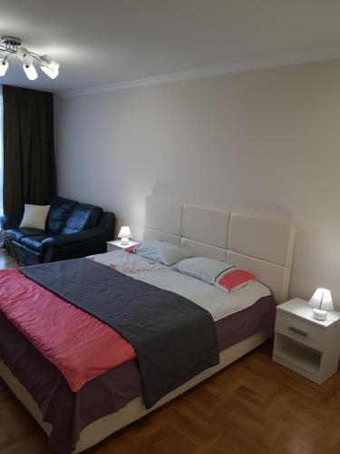 a bedroom with a large bed and a couch at Apartment in Ternopilʼ