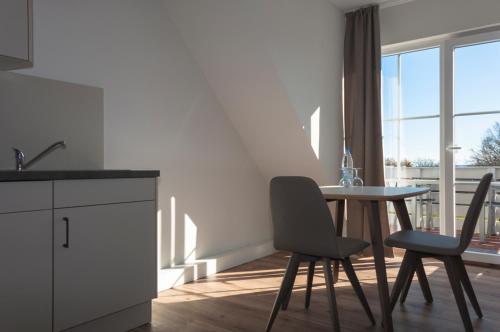 a kitchen with a table and chairs and a window at Lindenhof Hotel Garni in Sulsdorf auf Fehmarn