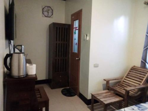 a room with a door and a chair and a table at Balai Mariacaria Pension House in Guindulman