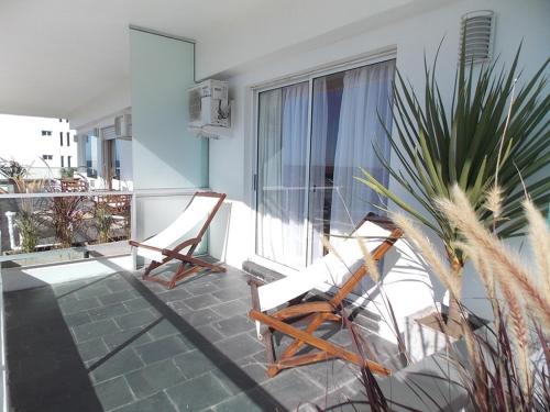 two chairs sitting on the balcony of a house at Apart Hotel Terrazas de San Francisco in Piriápolis