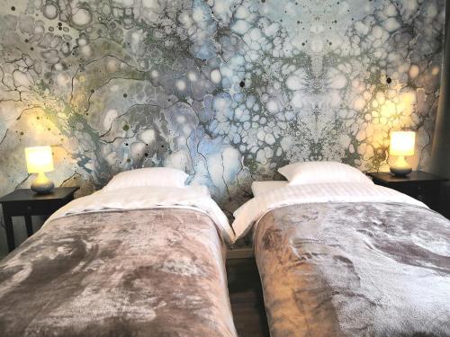 Duas camas num quarto com um mural de parede em City Apartment Savonkatu em Kuopio