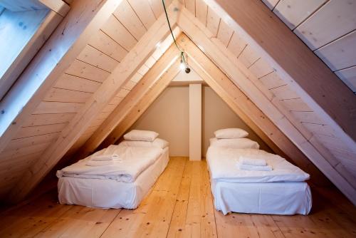 two beds in a attic bedroom with wooden floors at tvrz KRASSA in Osečná
