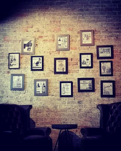 a brick wall with framed pictures on it at CocoBrew Boutique Apartments in Rockhampton