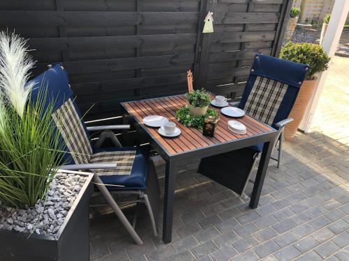a wooden table and chairs on a patio at Lieblingsplatz - Ferienwohnung Verse in Eddelak