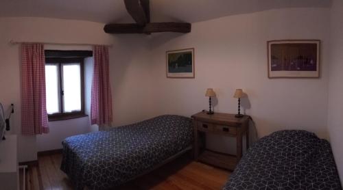 a bedroom with two beds and a window at Coutancie in Nanteuil-de-Bourzac