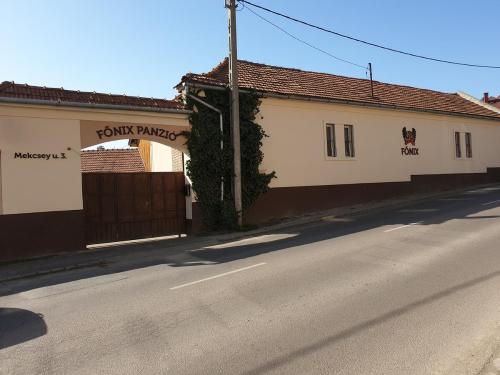 a street with two buildings on the side of a road at Főnix Panzió in Eger