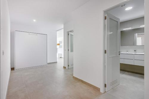 ein weißes Zimmer mit weißen Wänden und einer Küche in der Unterkunft Magnífico Bungalow con Vista Panorámica y Piscina Privada in Acantilado de los Gigantes