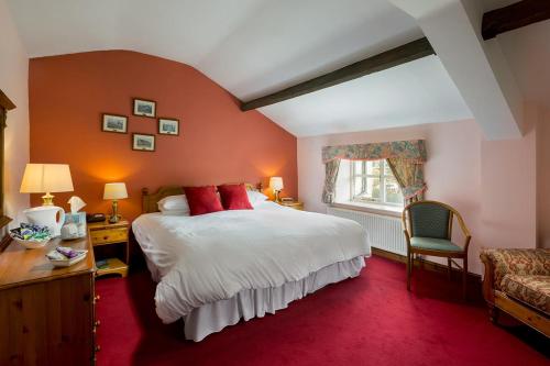 a bedroom with a large bed and a red carpet at The Queens Head Kettlesing in Harrogate