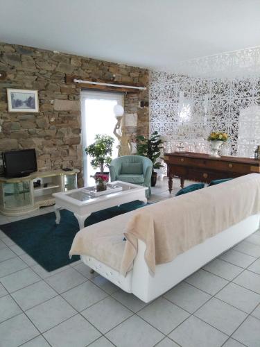 un salon avec deux lits et une table dans l'établissement Le Rumain, à Hengoat