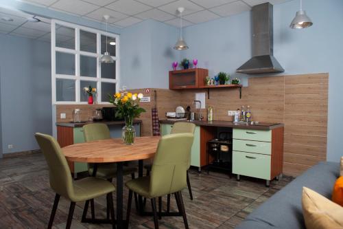 cocina con mesa de madera, sillas y encimera en Hostel Nikolskiy, en Yekaterinburg