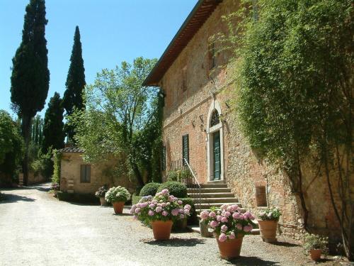 a brick building with potted plants on the side of it at Fattoria del Colle in Trequanda