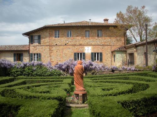 a statue in a garden in front of a building at Fattoria del Colle in Trequanda