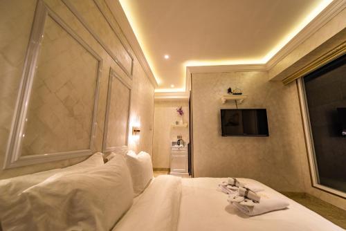 a bedroom with a bed with white sheets and a window at AC Residence - Behind Cititel Hotel in Kota Kinabalu