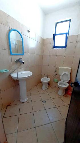 a bathroom with a sink and a toilet and a window at Vila Flamuri in Golem