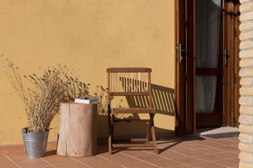 a wooden chair sitting on a porch next to a door at Terremesu a Castiadas Villasimius Costa Rei in Castiadas
