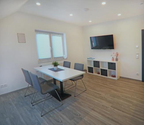 Sala de conferencias con mesa, sillas y TV en CityPension-Vreden, en Vreden