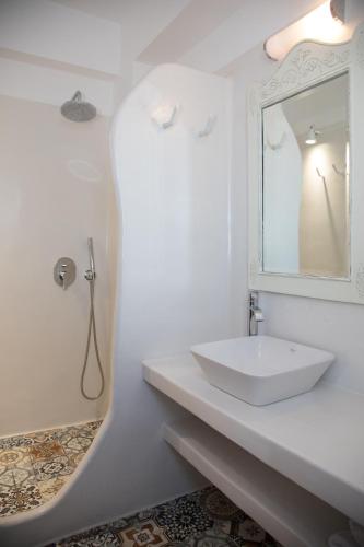 a white bathroom with a sink and a mirror at Costa Marina Villas in Fira