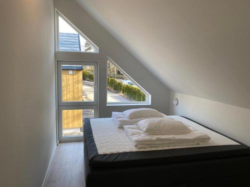 Ce lit se trouve dans un dortoir doté d'une grande fenêtre. dans l'établissement Årostunet 4K Nær Kristiansand dyrepark, à Søgne