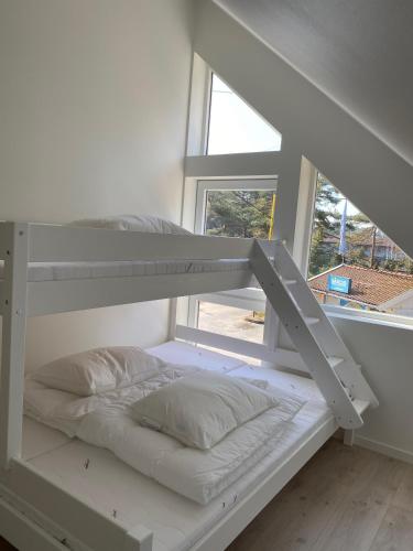 a white bunk bed in a room with a window at Sørlandet, nær stranden og Kristiansand dyrepark in Søgne