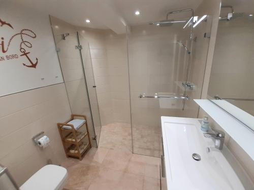 a bathroom with a shower and a toilet and a sink at Ankerplatz am Südstrand, Fewo mit 2 Schlafzimmer und eigenen Strandkorb in Binz