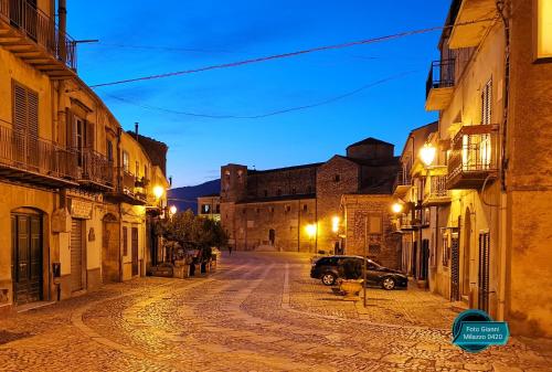 an empty street at night with a car parked at Albergo Ristorante Pizzeria Del Viale in Palazzo Adriano