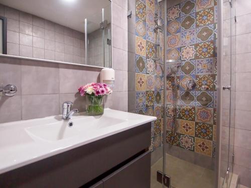 a bathroom with a sink and a shower with flowers at New Imperial Hotel in Jerusalem