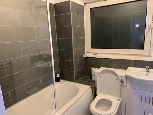 a bathroom with a toilet and a sink at London Stratford 4 Bedrooms Apartment in London