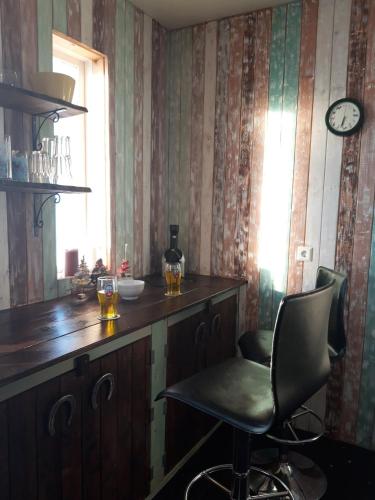 a bar with a chair and a clock on the wall at Stóri-Bakki Guesthouse-with hot tub in Egilsstadir