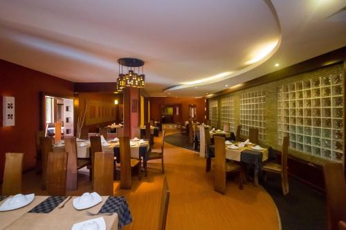 a restaurant with tables and chairs and a chandelier at KenGen Furnished and Serviced Apartments in Nairobi