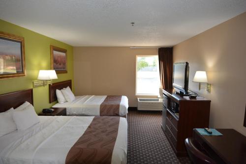 um quarto de hotel com duas camas e uma televisão de ecrã plano em Jameson Inn and Suites Hazelhurst em Hazlehurst
