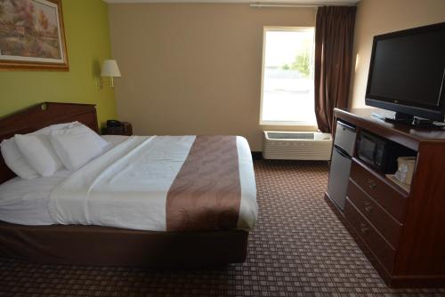 a hotel room with a bed and a flat screen tv at Jameson Inn and Suites Hazelhurst in Hazlehurst