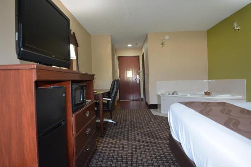 a hotel room with a bed and a flat screen tv at Jameson Inn and Suites Hazelhurst in Hazlehurst