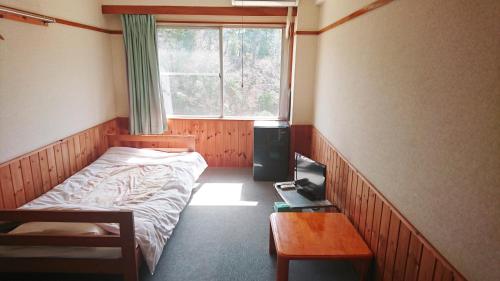 a small bedroom with a bed and a window at Hotel Sunrise in Onagawa