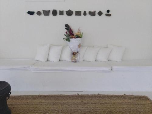 a white couch with pillows and a plant on it at Byron Springs in Byron Bay