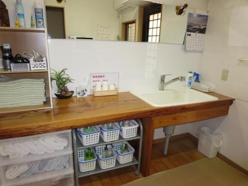 a bathroom vanity with a sink and a mirror at Guesthouse Suzukaze in Shibushi
