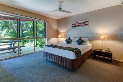 a bedroom with a bed and a large window at Cooinda Gardens on Hamilton Island by HIHA in Hamilton Island