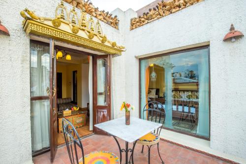 a patio with a table and chairs and a balcony at Baber Mahal Vilas - The Heritage Hotel in Kathmandu