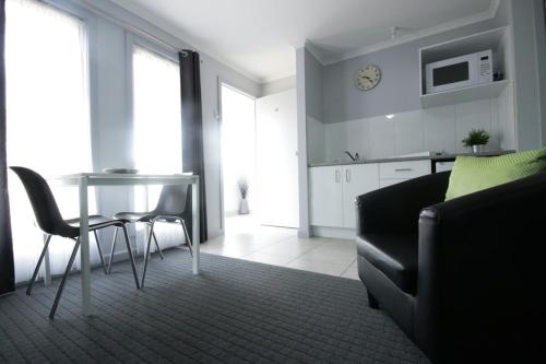 a living room with a table and a couch at Golden Palms Motel in Geelong