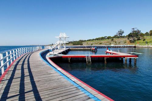 a wooden bridge over the water with people on it at Golden Palms Motel in Geelong