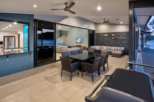 a dining room and living room with a table and chairs at Edge Apartments on Hamilton Island by HIHA in Hamilton Island