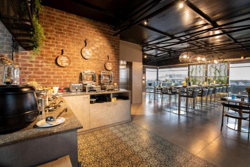 班加罗尔Hotel Avora Tree By Rivido Kempegowda Airport Road的一间带柜台的厨房和一间带桌子的酒吧